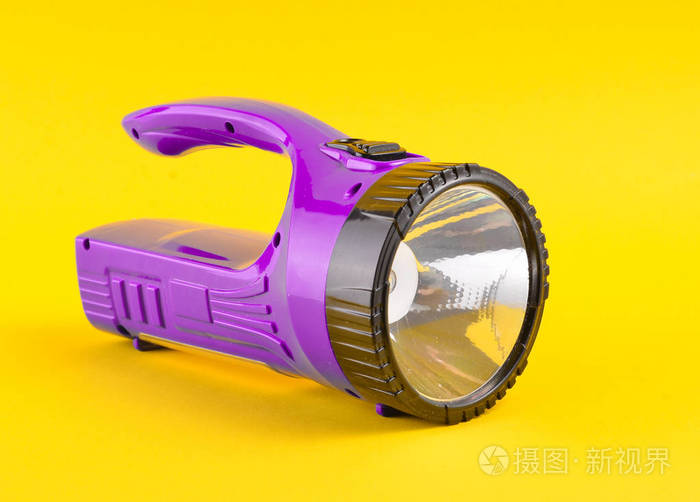 在黄色背景上隔离的紫色手电筒