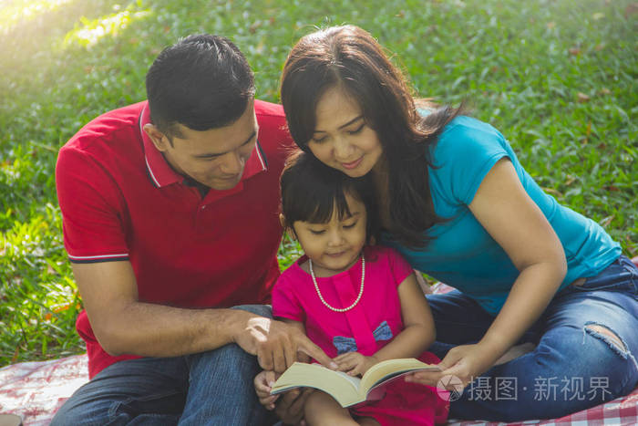在公园里合上一本家庭读物的肖像