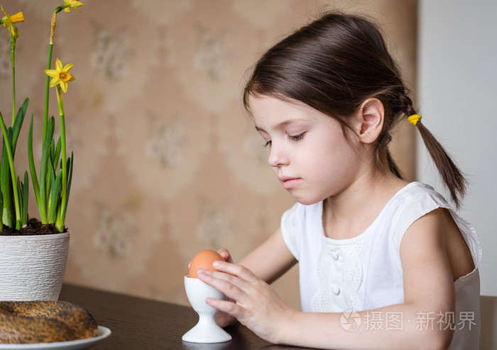 学龄前儿童女孩与早餐的复活节彩蛋