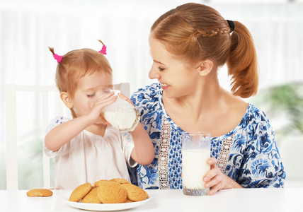 快乐家庭母亲和女儿女婴在早餐 饼干