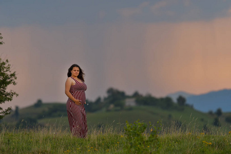 一个怀孕的妇女在日落风景