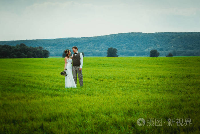 新郎新娘站在田野的背景上