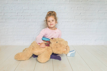 女孩, 一个孩子扮演医生, 测量熊玩具的压力