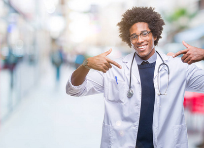 美国黑人医生在孤立的背景下, 脸上露出自信的笑容, 用手指自豪和快乐地指着自己。