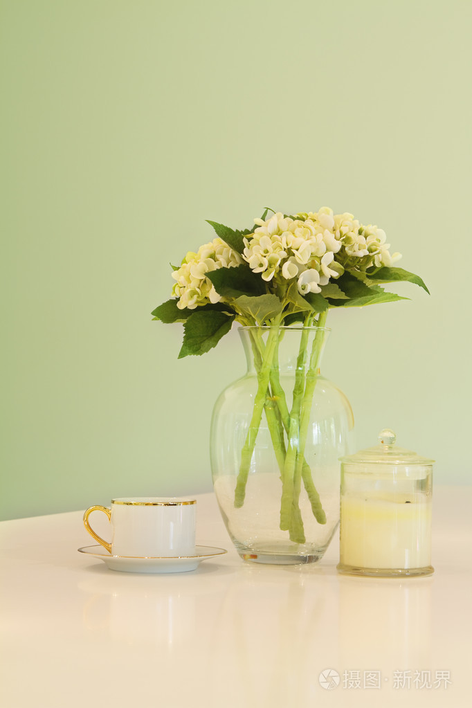花瓶的花和茶杯在软绿色柔和的色调