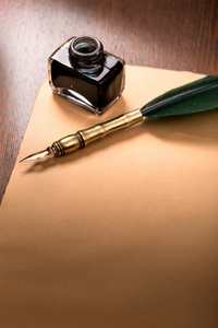 鹅毛笔和纸放在木桌图片