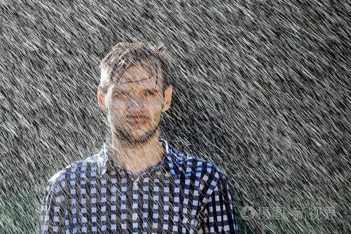 戴帽子的农夫正在享受雨夏天雨下的年轻人被淋湿了