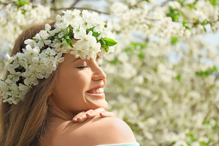 春天, 美丽的年轻女子穿着花花环在户外
