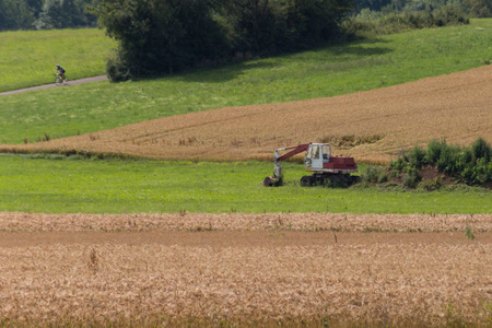 挖掘机与小屋和地球在玉米地农村风景在德国南部农村在慕尼黑和 stutusterich 城市附近