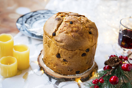 帕内托内意大利甜面包在节日圣诞餐桌设置与蜡烛和装饰