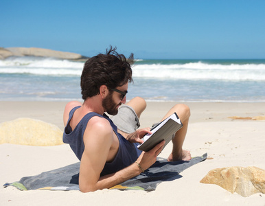 年轻人在僻静的海滩上看书