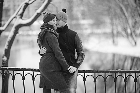 年轻人和妇女拥抱在冬季公园, 浪漫的幸福夫妇