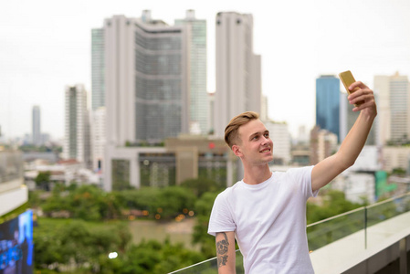 年轻英俊的男人拿着手机自拍