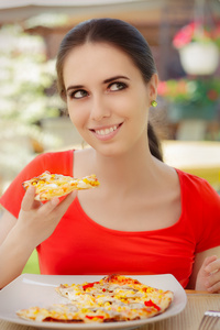 幸福的年轻女人吃披萨