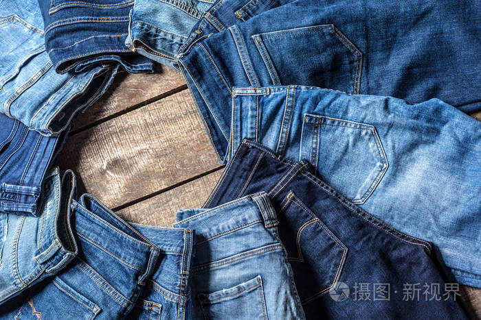关闭在木背景的牛仔裤