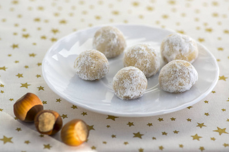 圣诞曲奇, 美味的球与榛子里面和糖衣, 白色板和金色的星星桌布