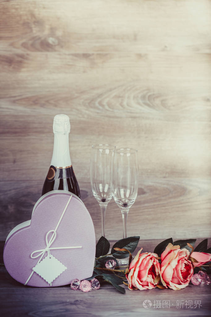 情人节。香槟, 酒杯, 玫瑰和礼物在一个盒子里。预约, 生日。理念 幸福, 节日