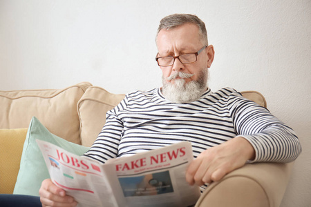 读报纸在家里的老人