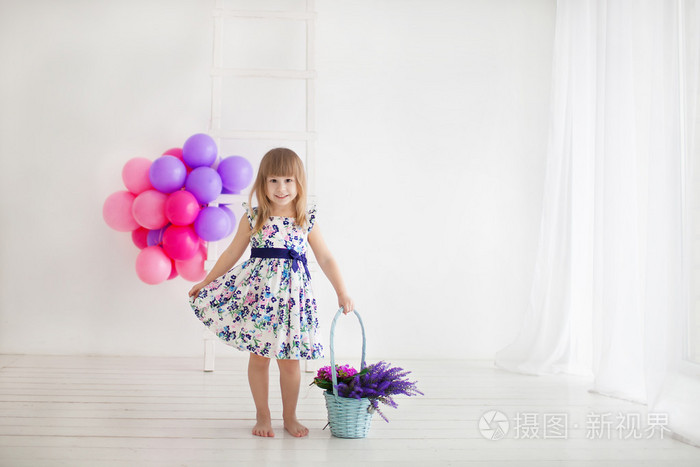 美丽的女孩，附近的鲜花和气球的篮子