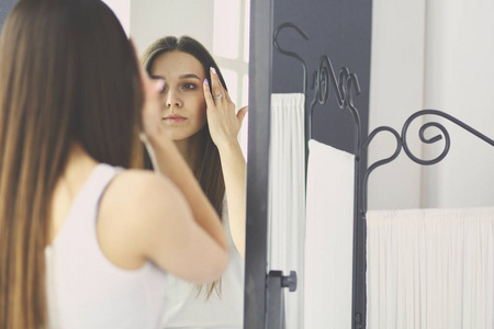 看自己在家里的镜子中反射的年轻女人