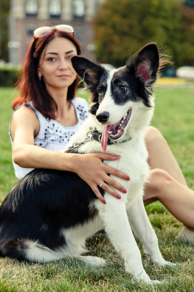 女孩与边境牧羊犬狗在公园散步
