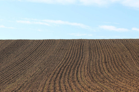 犁沟行中犁过的田野,在春天准备种植作物的模式.在视角的水平视图照片