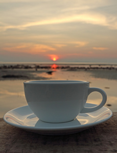 每天早上喝咖啡杯子在海边与大海天空背景图片