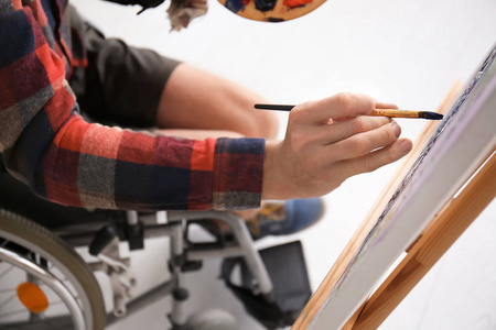 年轻的艺术家在轮椅绘画图片, 特写镜头