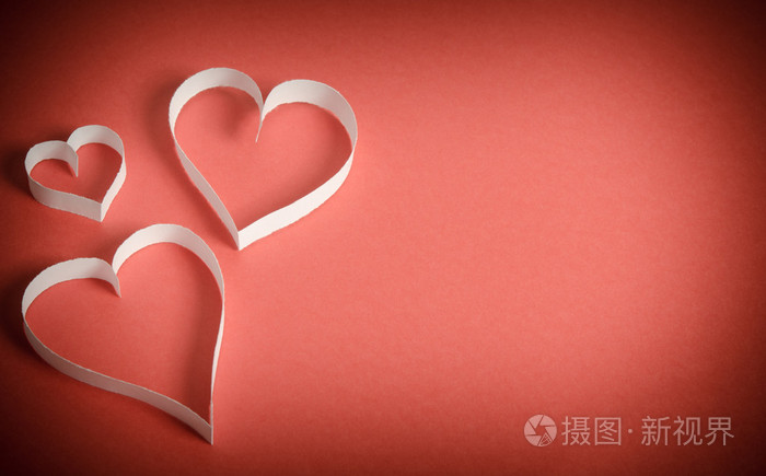 白皮书躺在红色的背景上的三颗心