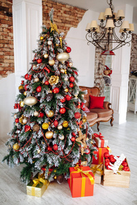 圣诞节和新年装饰的室内房间与红色礼物和新年树和古典棕色沙发在白色墙壁前面