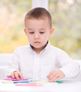 小男孩在白色纸上绘图