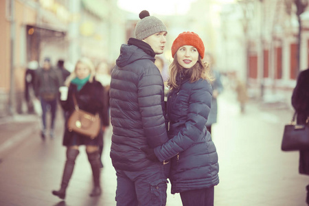 年轻的男人和女人走在冬天的城市, 浪漫的幸福夫妇