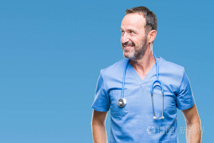 中年白发高级医生穿医疗制服在孤立的背景上看着一边面带微笑自然表情