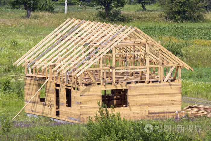 新的木制平房, 天然木材材料与陡峭的木板屋顶框架在建的绿色邻里.