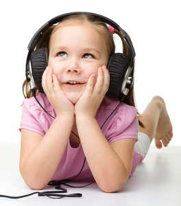 可爱的小女孩享受音乐使用头戴式耳机