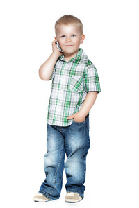 一个小男孩在讲电话。在白色隔离