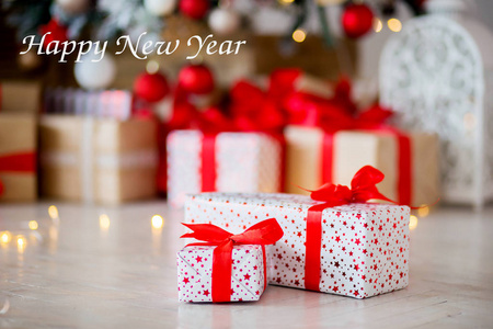 红色包装的礼物放在地板上, 背景是其他礼物。新年快乐