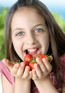一个孩子用水果，水果的女孩