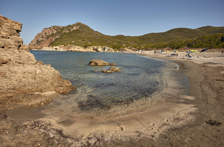 撒丁岛卡拉萨菲古海滩的美丽鸟图, 其清澈的大海, 在该海岸典型的岩石山脉的壮观背景中与有色沙滩相遇