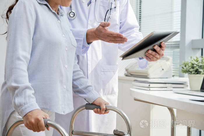 白大衣医生在咨询伤害病人时使用数码片