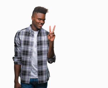 年轻的非洲裔美国人在孤独的背景微笑着愉快的脸眨眨眼在相机做胜利标志。第二个