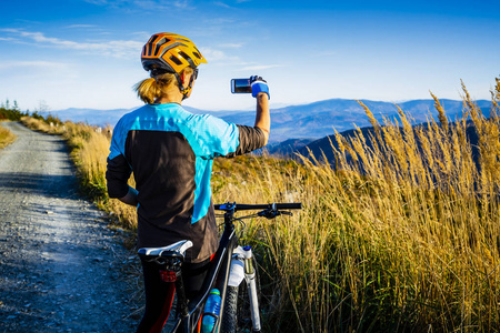 骑自行车的妇女在秋天的山森林风景。骑自行车 mtb 流动小道轨道的妇女。户外运动活动