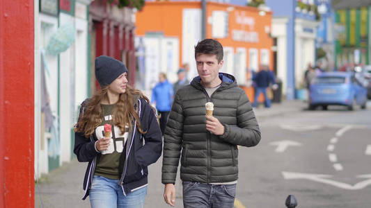 快乐夫妇在街上散步时吃冰淇淋