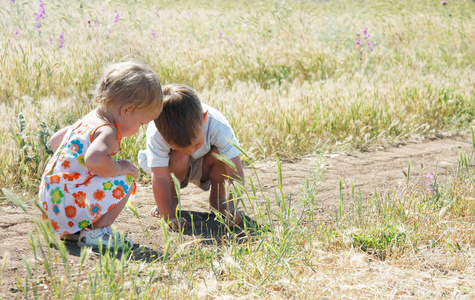 两个孩子在草丛中的捕捉