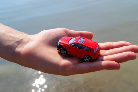 红色汽车在孩子的手对海, 夏天的节日和汽车儿童