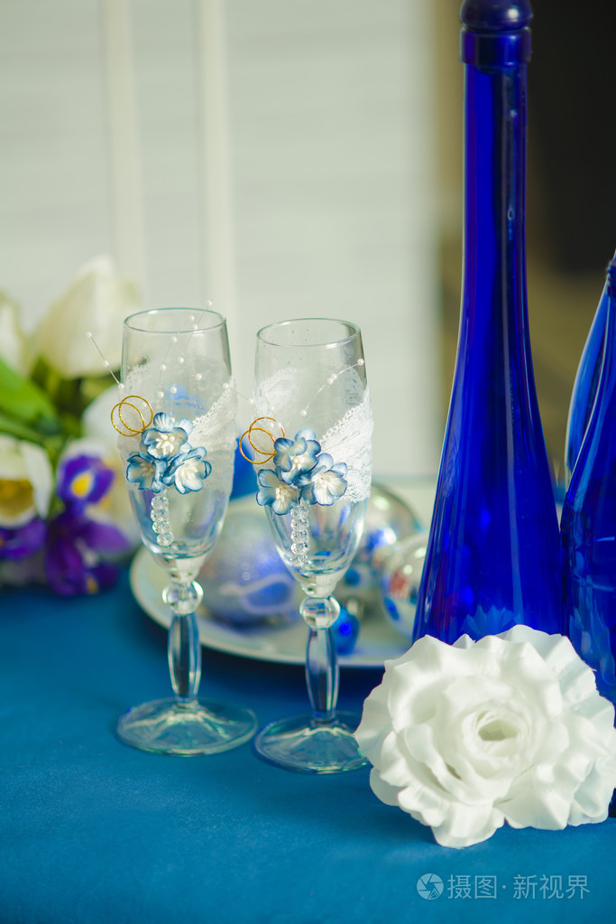 新娘捧花的蓝色虹膜白色郁金香玻璃杯和玻璃瓶