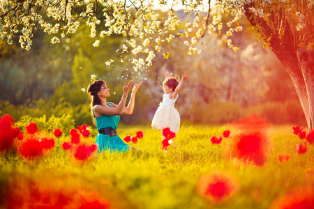 幸福的女人和孩子在盛开春 garden.mothers 天