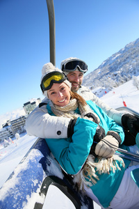 夫妇在滑雪度假村的升降椅