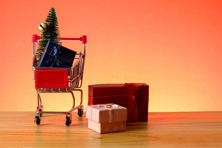 新年概念与购物车, 礼品盒和圣诞树在一张木桌上