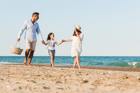 快乐的年轻家庭在海滩上玩的形象